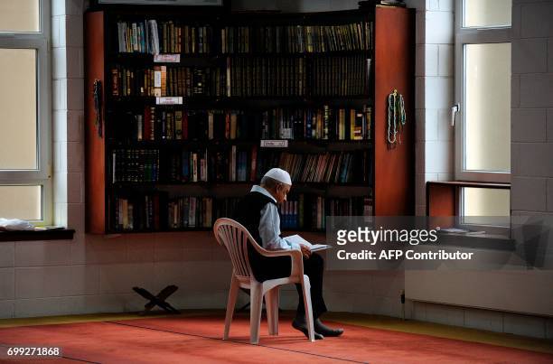 Man reads as Scotland's First Minister and Scottish National Party leader Nicola Sturgeon meets worshippers during a visit to Dundee Central Mosque...