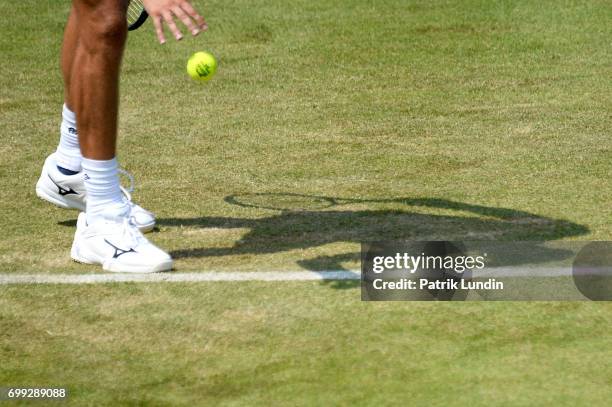 Gilles Muller of Luxemburg bounce the ball during the 2nd round match against Jo-Wilfried Tsonga of France on day three at Queens Club on June 21,...