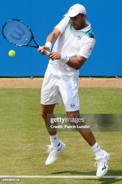 Gilles Muller of Luxemburg hits a backhand during the 2nd round match against Jo-Wilfried Tsonga of France on day three at Queens Club on June 21,...