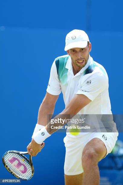Gilles Muller of Luxemburg hits a backhand during the 2nd round match against Jo-Wilfried Tsonga of France on day three at Queens Club on June 21,...