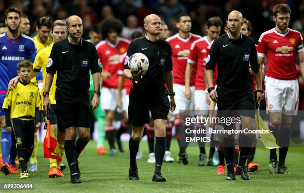 Match referee Lee Mason leads the team's out onto the pitch