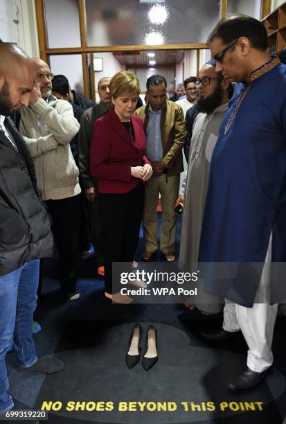 Scotland's First Minister and Scottish National Party leader Nicola Sturgeon puts her shoes on after meeting worshippers during a visit to Dundee...