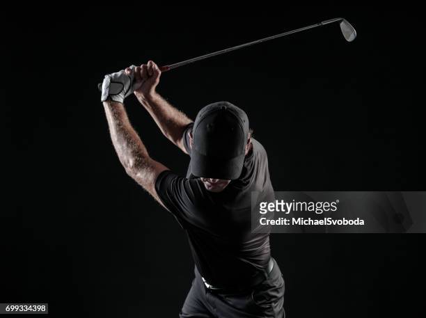 dramatic image of a male golfer at the top of his swing - golfer stock pictures, royalty-free photos & images