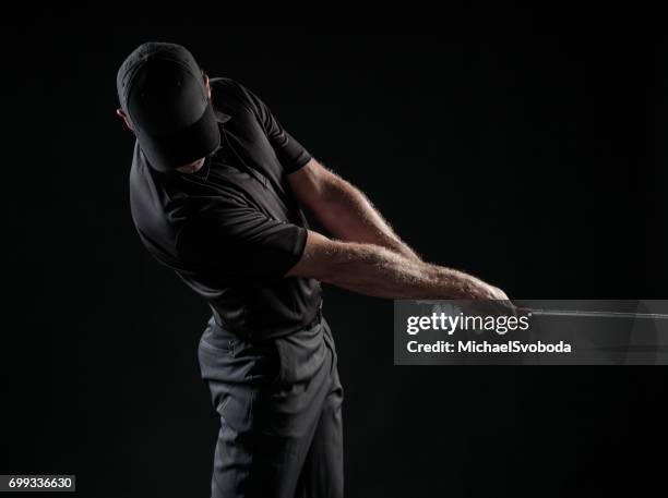 dramatic image of a male golfer in mid swing - golfer swing stock pictures, royalty-free photos & images