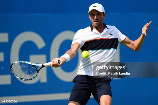 Julien Benneteau of France hits a forehand during the 2nd round match against Grigor Dimitrov of Bulgaria on day three at Queens Club on June 21,...