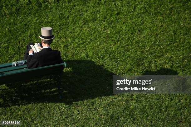 Spectator reads the racecard on Day Two of Royal Ascot at Ascot Racecourse on June 21, 2017 in Ascot, England.