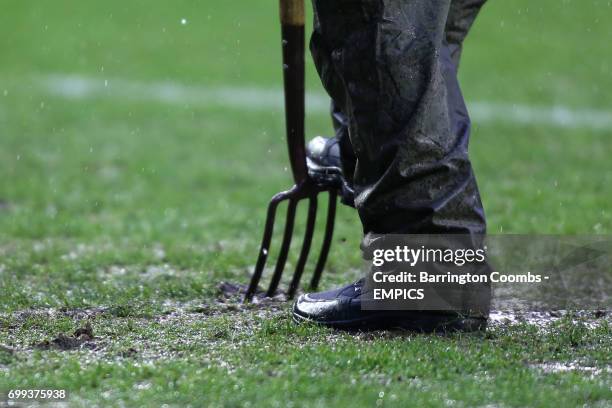 Groundsman tends to the pitch with a fork