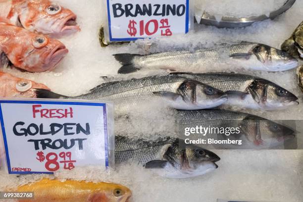 Branzino, golden trout, and other fresh fish are displayed for sale inside the Pike Place Market in Seattle, Washington, U.S., on Wednesday, May 17,...