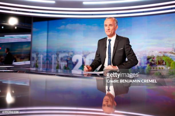 French TV presenter Gilles Bouleau looks on prior to present in the evening news broadcast of French TV channel TF1, in June 21 in the TF1 studios in...