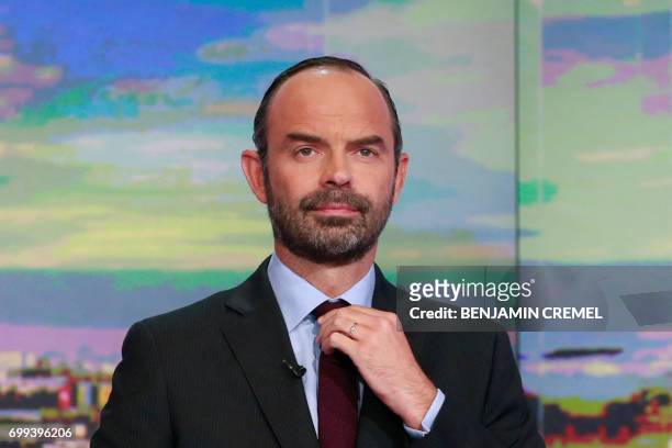 French Prime Minister Edouard Philippe arranges his tie prior to taking part in the evening news broadcast of French TV channel TF1, in June 21 in...