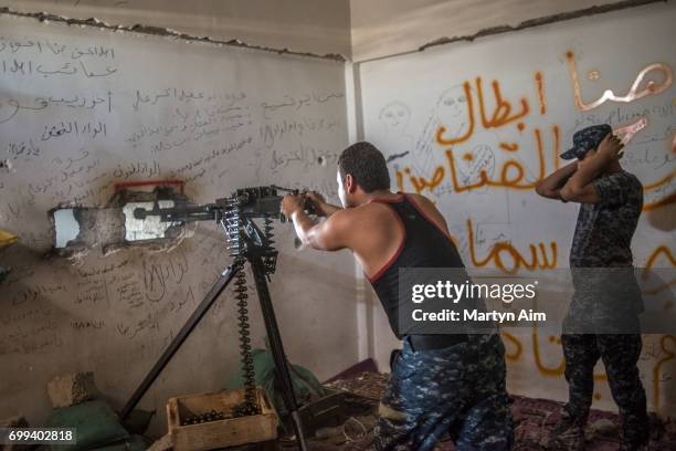 An Iraqi Federal Police soldier fires a 50. Calibre machine at Islamic State militants in Bab Jded, west Mosul, Iraq on June 21, 2017. Islamic State...