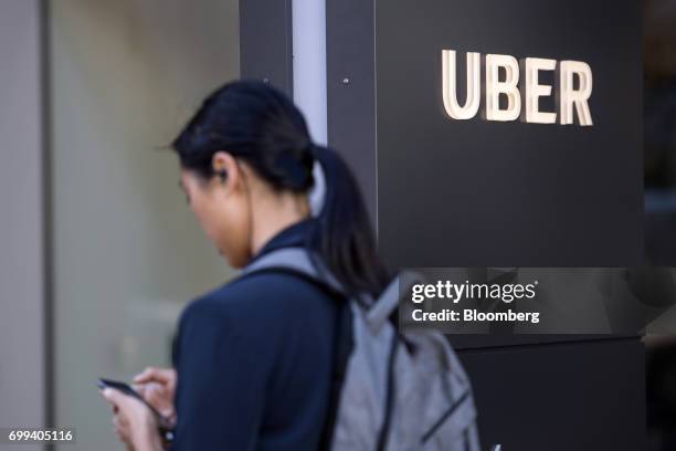 Pedestrian checks a mobile device in front of the Uber Technologies Inc. Headquarters building in San Francisco, California, U.S., on Wednesday, June...