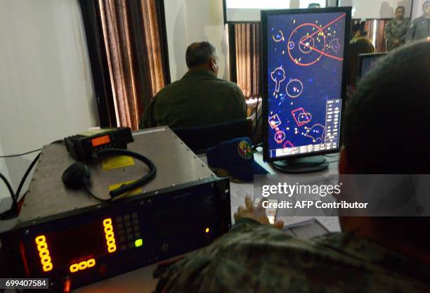 Members of a tri-national Air Force team of Brazil, Colombia and Peru watch from a control center the joint exercises designed to improve tactics and...