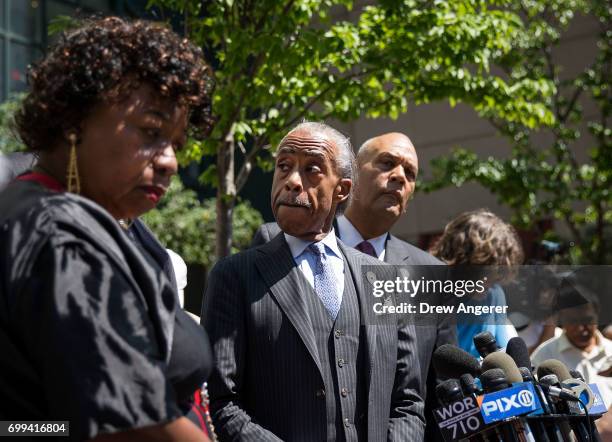 Gwen Carr, mother of the late Eric Garner, and Rev. Al Sharpton listen to questions from the press after meeting with Department of Justice...