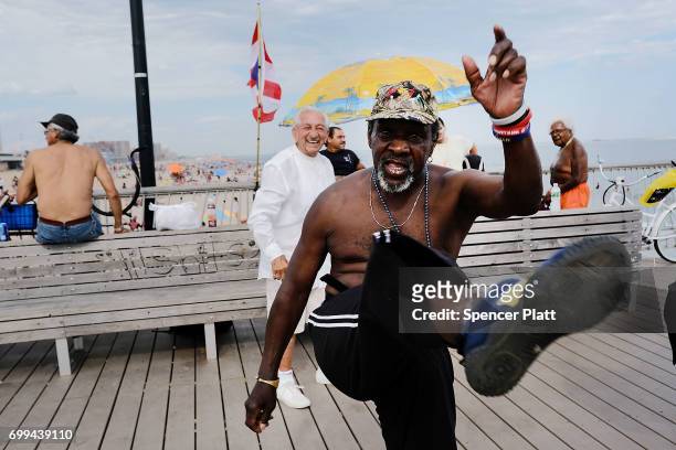 People relax along the boardwalk at Coney Island on the first day of summer on June 21, 2017 in New York City. Following an unseasonably wet spring,...