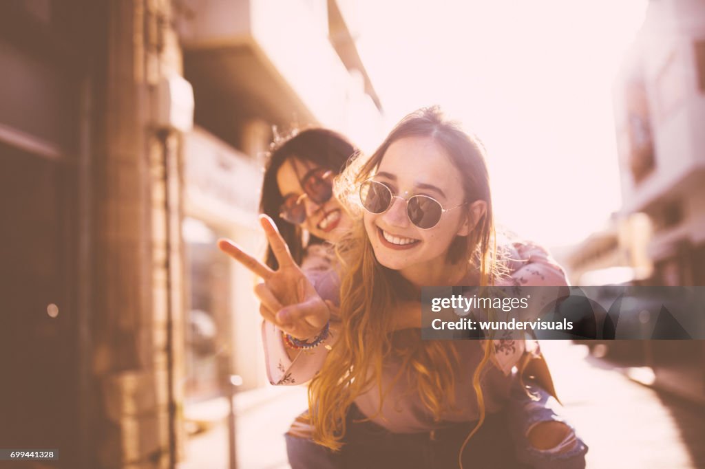 Young woman on piggyback ride doing the peace sign