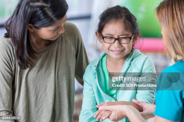 upset girl with injured arm - injured hand stock pictures, royalty-free photos & images