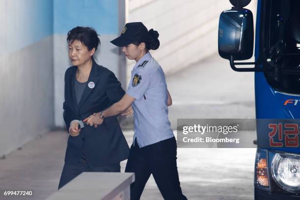 Park Geun-hye, former president of South Korea, left, is escorted by a prison officer as she arrives at the Seoul Central District Court in Seoul,...