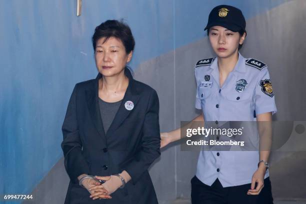 Park Geun-hye, former president of South Korea, left, is escorted by a prison officer as she arrives at the Seoul Central District Court in Seoul,...