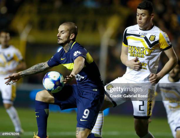 Dario Benedetto of Boca Juniors competes for the ball with Carlos Rodriguez of Olimpo during a match between Olimpo and Boca Juniors as part of...