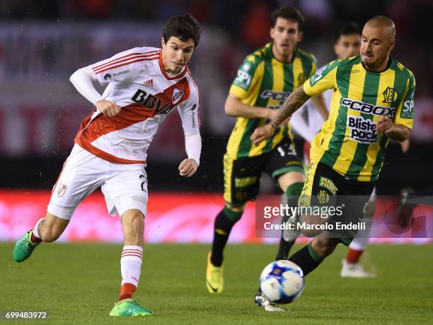 Ignacio Fernandez of River Plate plays the ball followed by Roberto Brum of Aldosivi during a match between River Plate and Aldosivi as part of...