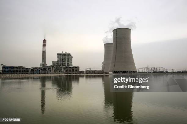 Vapor rises from cooling towers and a smokestack at the Sahiwal coal power plant, owned by China's state-owned Huaneng Shandong Rui Group, in...