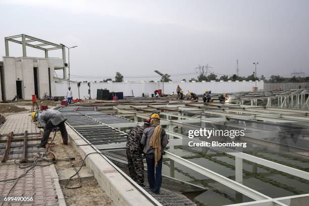 Chinese and Pakistani workers labor at a construction site at the Sahiwal coal power plant, owned by China's state-owned Huaneng Shandong Rui Group,...