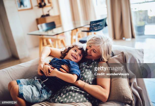 hermosa abuela y nieto jugando juntos divirtiéndose en casa - abuelos fotografías e imágenes de stock