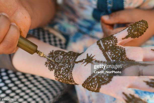 Maroccan girl has decorative henna designs applied to her hands at a roadside stall ahead of Laylat al-Qadr celebrations in Rabat, Morocco, on 21...