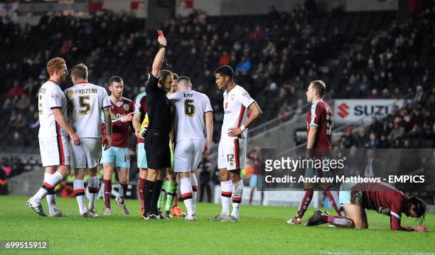 Milton Keynes Dons' Antony Kay is shown a red card by referee Stephen Martin after he brings down Burnley's George Boyd outside of the box