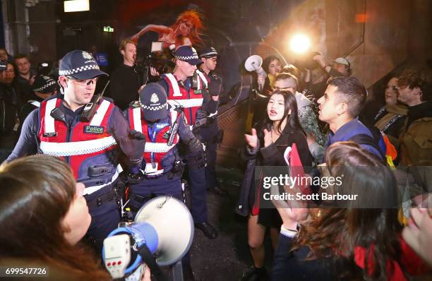 Police officers attempt to stop protesters from storming the back entrance to the Athenaeum club, where former Australian tennis player and Christian...