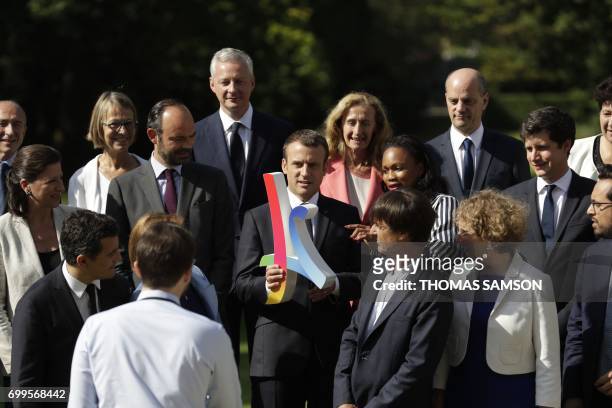 French president Emmanuel Macron poses with the 2024 Olympic's logo with the members of the governement French Minister of the Interior Gerard...