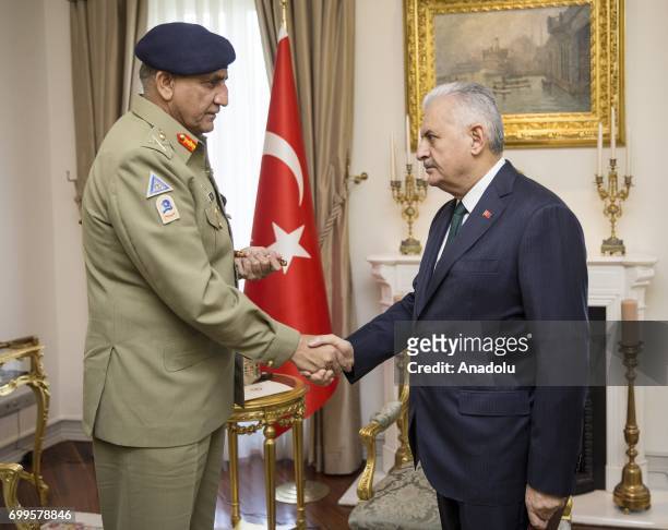 Turkish Prime Minister Binali Yildirim shakes hands with Pakistani Army Chief General Qamar Javed Bajwa ahead of their meeting at Cankaya Palace in...