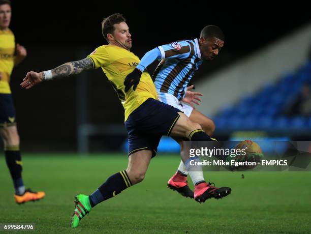 Oxford United's Chris Maguire and Mansfield Town's Reggie Lambe battle for the ball