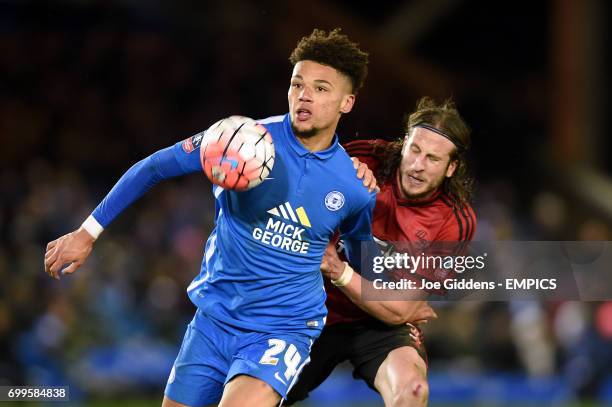 Peterborough United's Lee Angol and West Bromwich Albion's Jonas Olsson battle for the ball