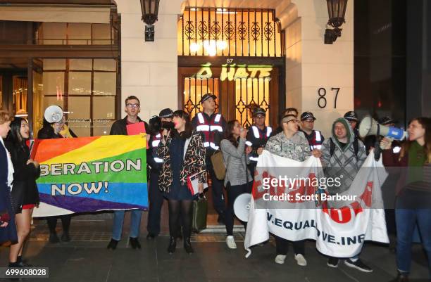Protesters hold aloft placards outside of the Athenaeum club, where former Australian tennis player and Christian pastor Margaret Court is the...