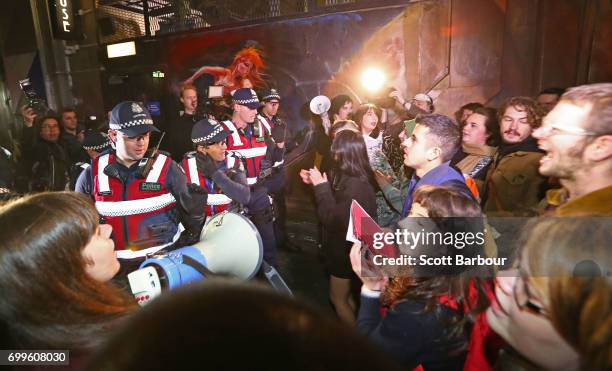 Police officers attempt to stop protesters from storming the back entrance to the Athenaeum club, where former Australian tennis player and Christian...