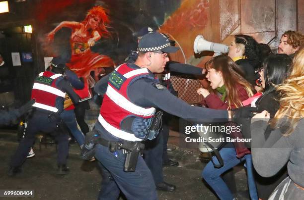 Police officers attempt to stop protesters from storming the back entrance to the Athenaeum club, where former Australian tennis player and Christian...