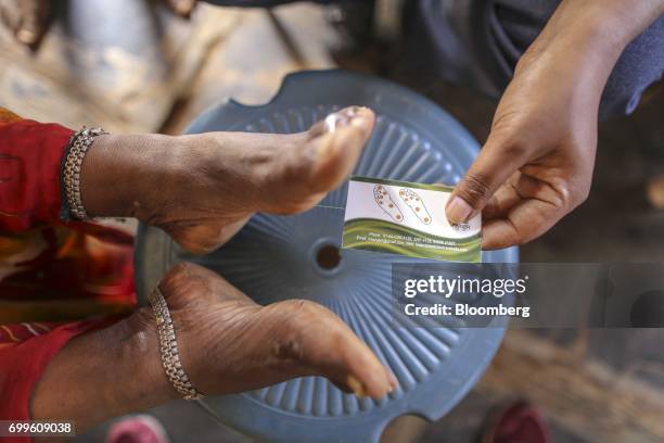 Member of the medical staff from the Jain Institute of Vascular Sciences examines the feet of a patient at a mobile clinic in Pancharala, on the...