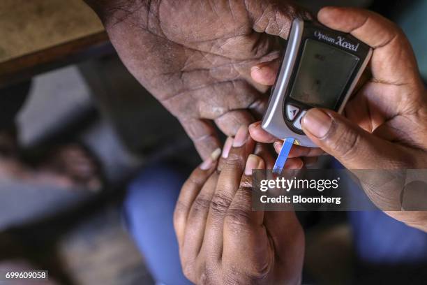 An member of the Jain Institute of Vascular Sciences medical team uses an Abbot India Ltd. FreeStyle Optium glucometer to check the blood glucose...