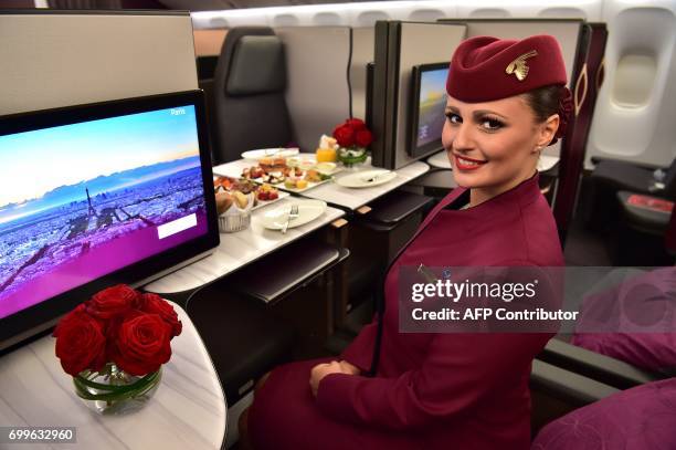 An air hostess sits in the 'QSuite' business class of a Qatar Airways Boeing 777 jet airliner on display at the International Paris Air Show in Le...