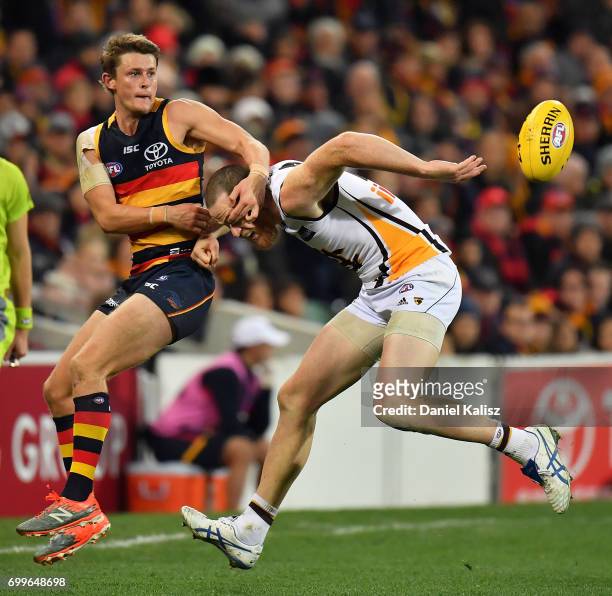 Matt Crouch of the Crows competes for the ball with Jarryd Roughead of the Hawks during the round 14 AFL match between the Adelaide Crows and the...