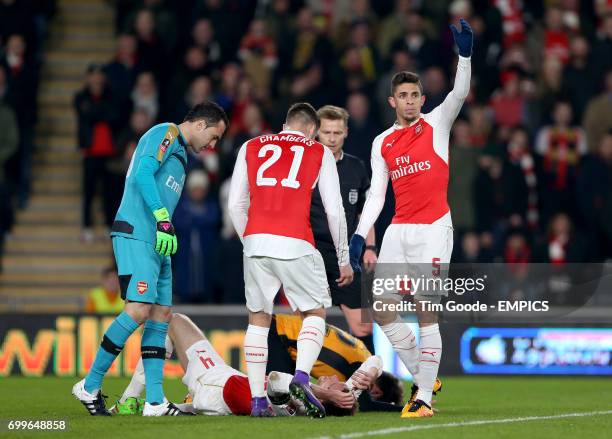 Arsenal's goalkeeper David Ospina, Calum Chambers and Gabriel Paulista react as Per Mertesacker collides with Hull Citys Nick Powell