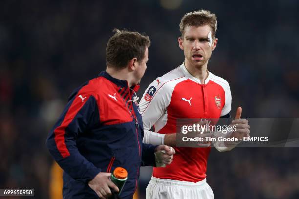 Arsenal's Per Mertesacker speaks with Arsenal staff