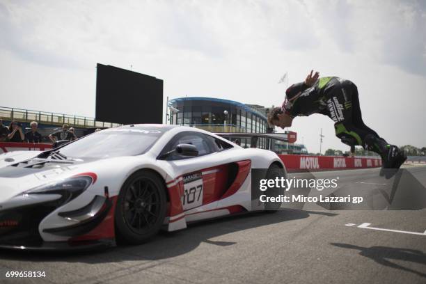 Johann Zarco of France and Monster Yamaha Tech 3 makes a backflip during the pre-event "A race between a Yamaha M1 and a McLaren GT3" during the...