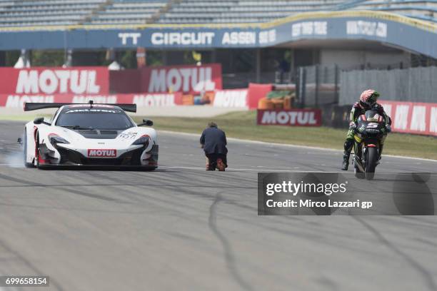 Johann Zarco of France and Monster Yamaha Tech 3 rides the bike and Bruno Senna of Brazil drives the car during the pre-event "A race between a...