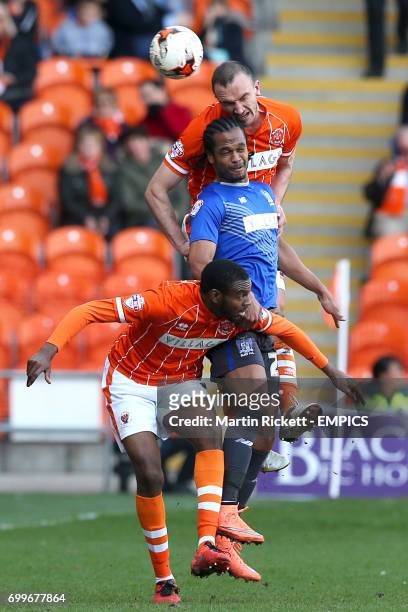 Blackpool's Hayden White and Tom Aldred battle for the ball in the air with Bury's Nathan Delfouneso