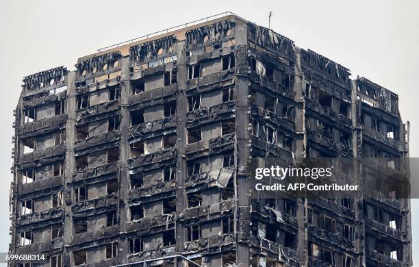The charred remains of clading are pictured on the outer walls of the burnt out shell of the Grenfell Tower block in north Kensington, west London on...