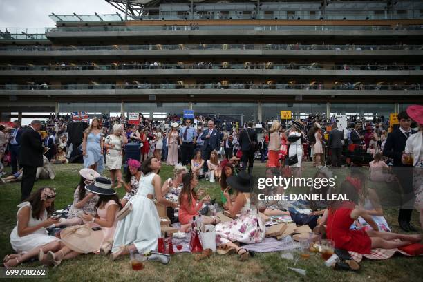 Racegoers enjoy a picnic in front of the grandstand on Ladies Day at the Royal Ascot horse racing meet, in Ascot, west of London, on June 22, 2017. -...