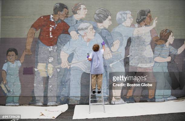 Regina Gaudette, of Lakeville, works to restore the iconic "Beat the Belt" mural in Cambridge, MA on Jun. 19, 2017. The 37 year old painting by...